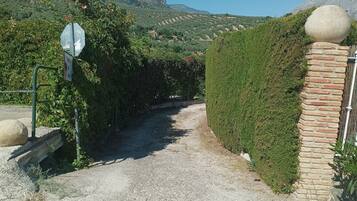Un chemin de gravier mène à une barrière sur laquelle est apposé un panneau de signalisation indiquant un arrêt et un autre panneau indiquant une zone de stationnement.