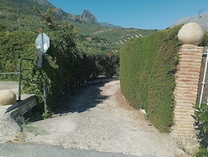 A gravel path leading to a gate with a stop sign and a sign indicating a parking area.
