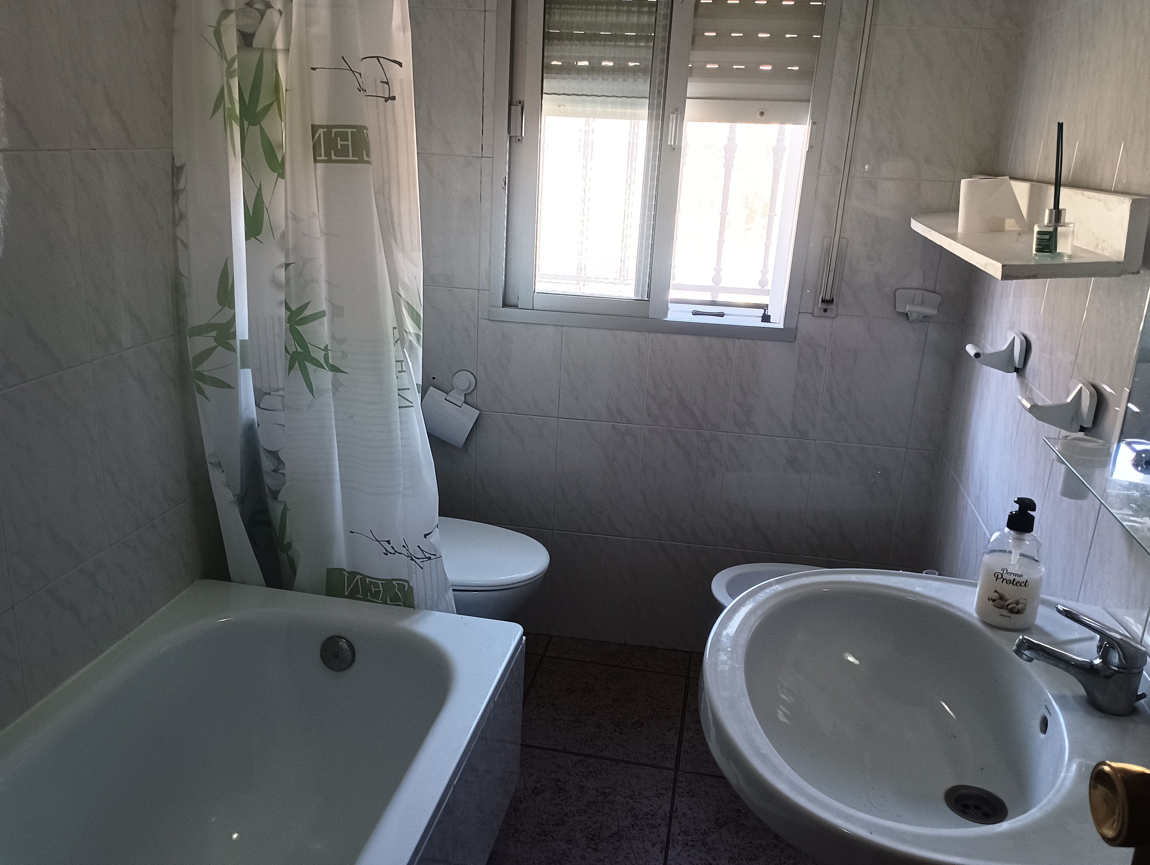 Une salle de bain avec une baignoire, des toilettes et un lavabo.