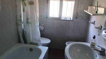 Une salle de bain avec une baignoire, des toilettes et un lavabo.