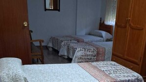 A room with three beds, a wooden wardrobe, and a mirror on the wall. - Bedmar Farmhouse (Bedmar)