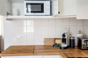 A kitchen with a microwave, a coffee maker, and a toaster on the counter.