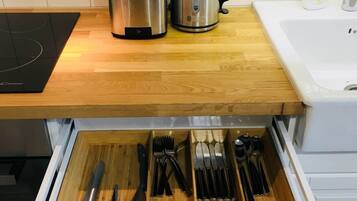 A kitchen with a toaster, kettle, and a drawer organizer for utensils.