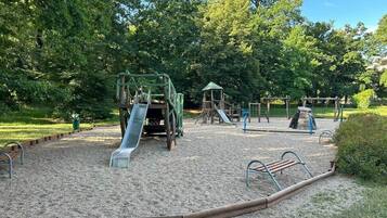 Een speeltuin met een glijbaan, schommels en klimtoestellen.