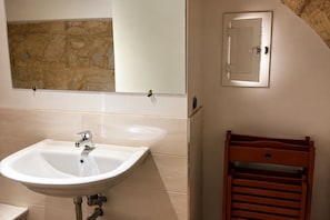A bathroom with a sink, mirror, and towel rack. - Charming Apartment Near Bari & Alberobello (Bitritto)
