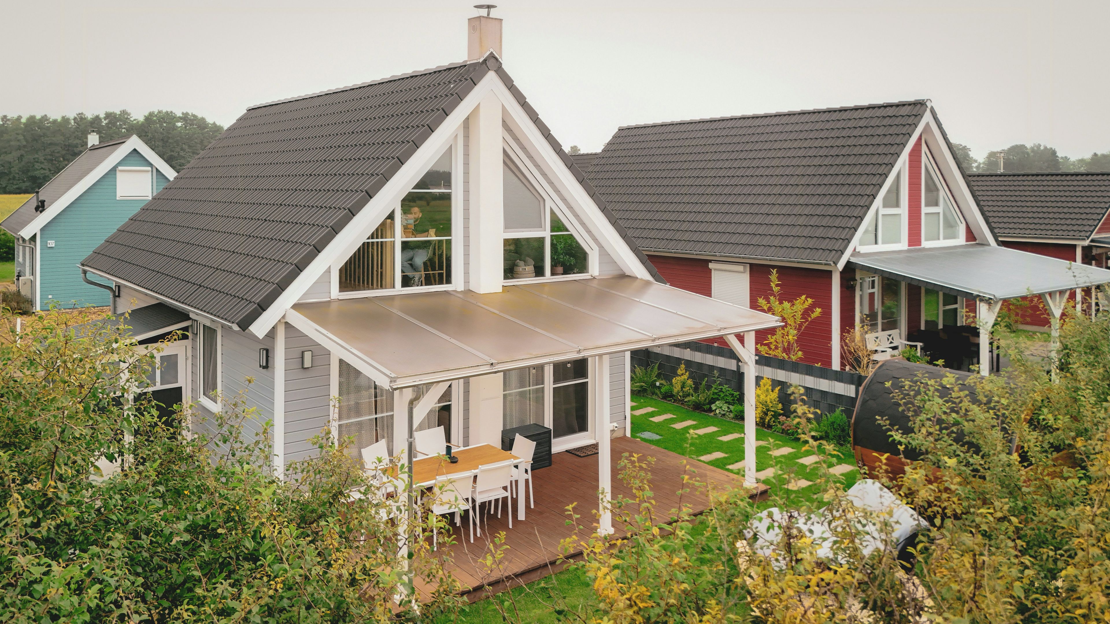 A residential property with a covered patio, a fenced backyard, and a neighboring house.