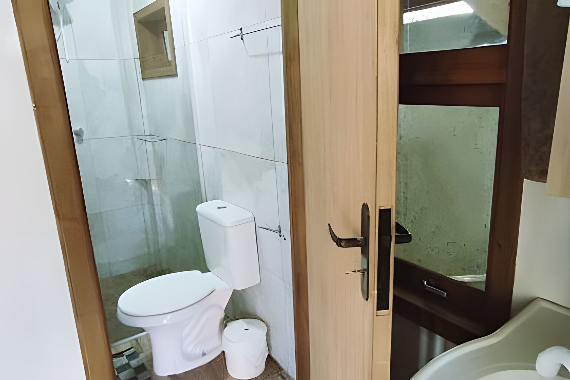 Um banheiro pequeno com vaso sanitário, pia e espelho.