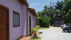 Una calle residencial con casas, un camino de entrada y coches estacionados.