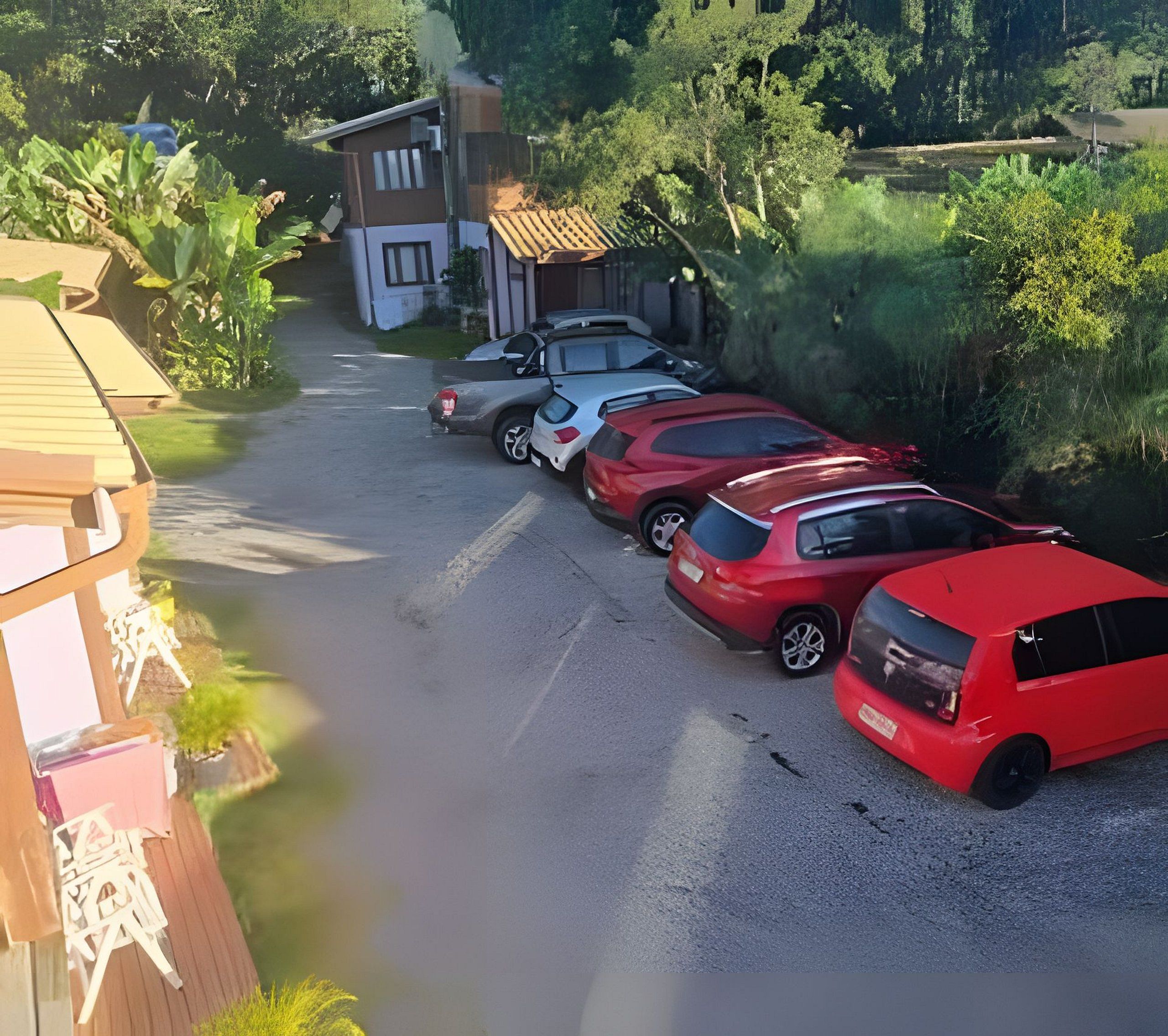 Un estacionamiento con varios autos estacionados a lo largo de un camino de grava.
