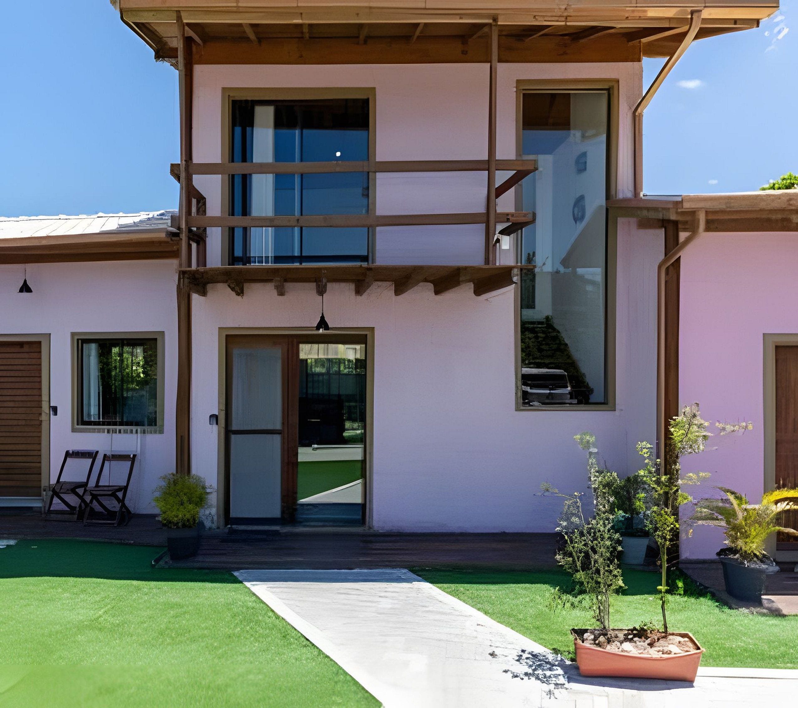 Una casa de dos pisos con puerta principal, un pequeño porche y una escalera que lleva a un piso superior.