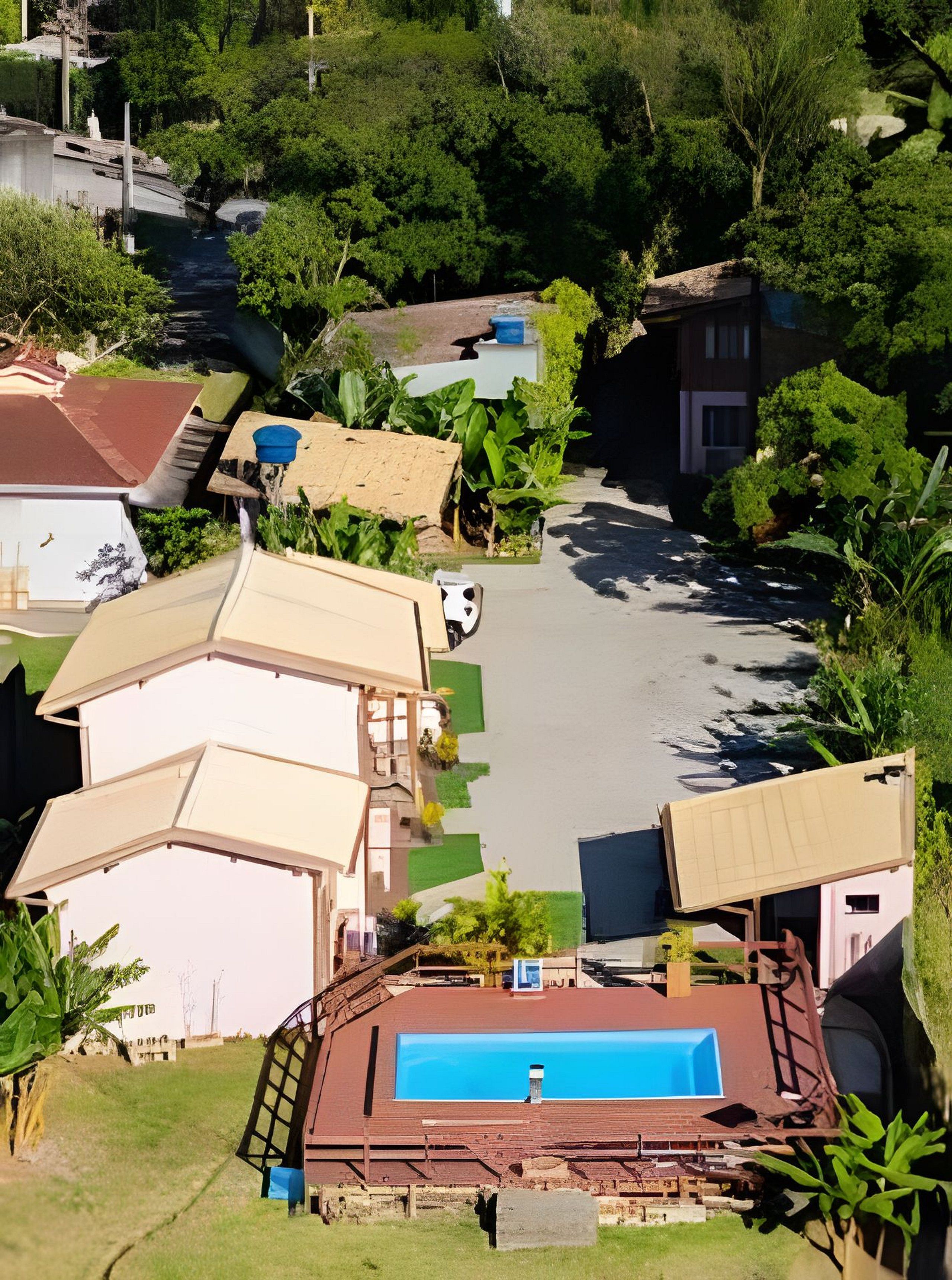 A residential area with multiple houses, a swimming pool, and lush greenery.