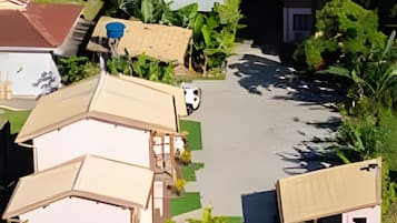 A residential area with multiple houses, a swimming pool, and lush greenery.