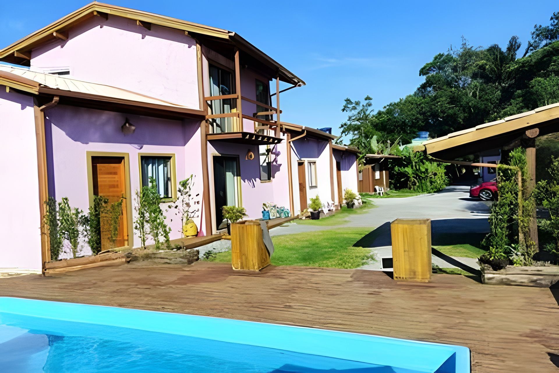 Un resort con piscina, varias habitaciones de huéspedes y un espacio exterior techado.