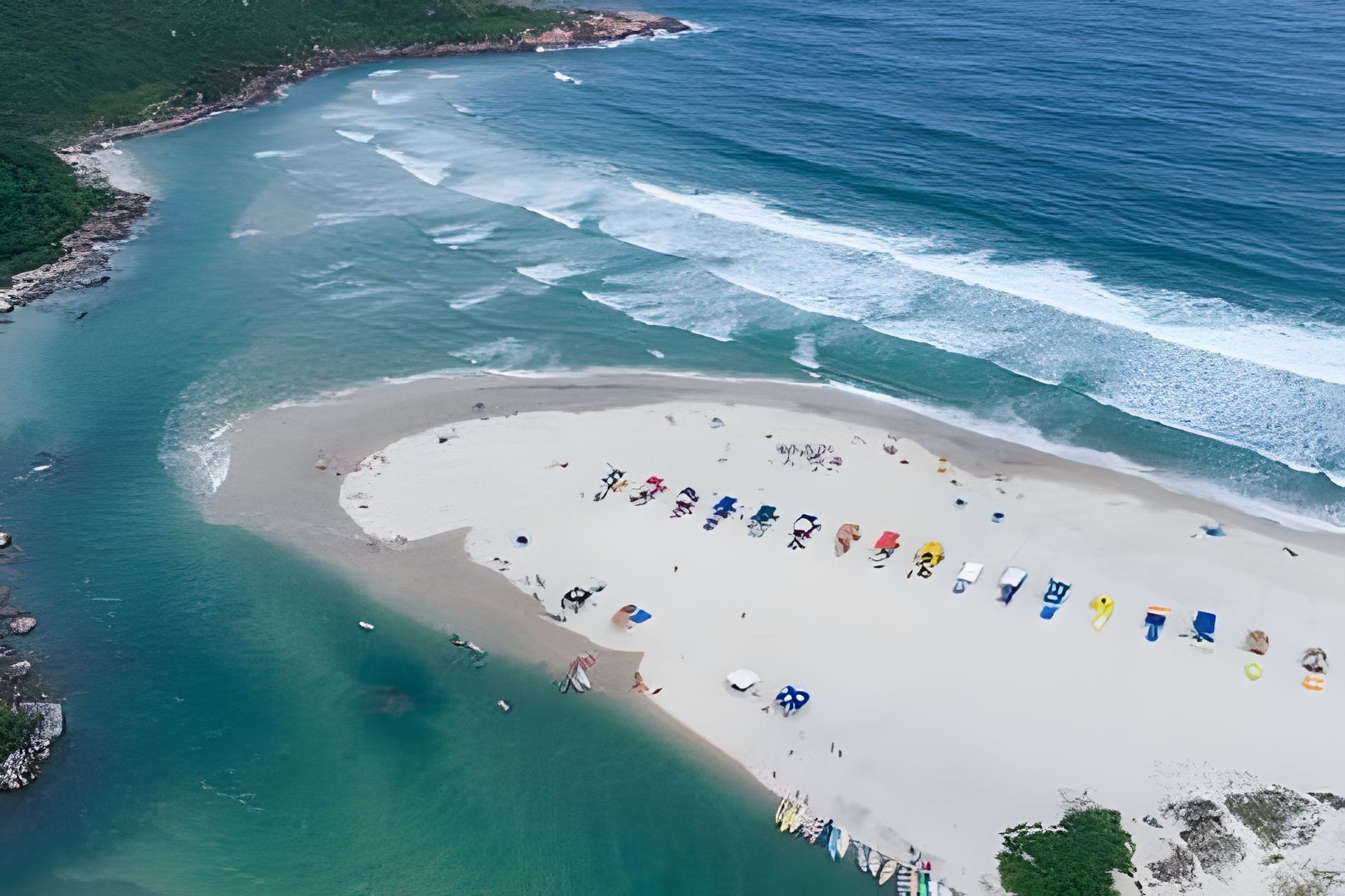 An aerial view of a beach with a sandy area and a row of beach chairs.