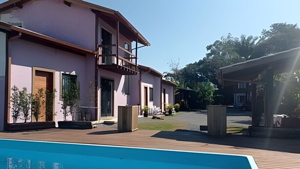 Un edificio moderno con piscina, zona de estar exterior y un área cubierta.