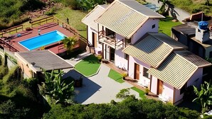 A residential property with a swimming pool, multiple rooms, and a garden.