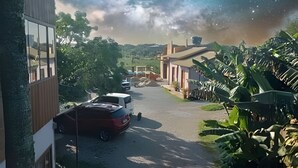Una calle residencial con casas, automóviles estacionados y abundante vegetación.