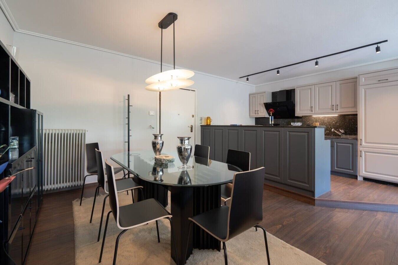 A modern kitchen with grey cabinets, a black countertop, and a central island.