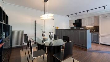 A modern kitchen with grey cabinets, a black countertop, and a central island.