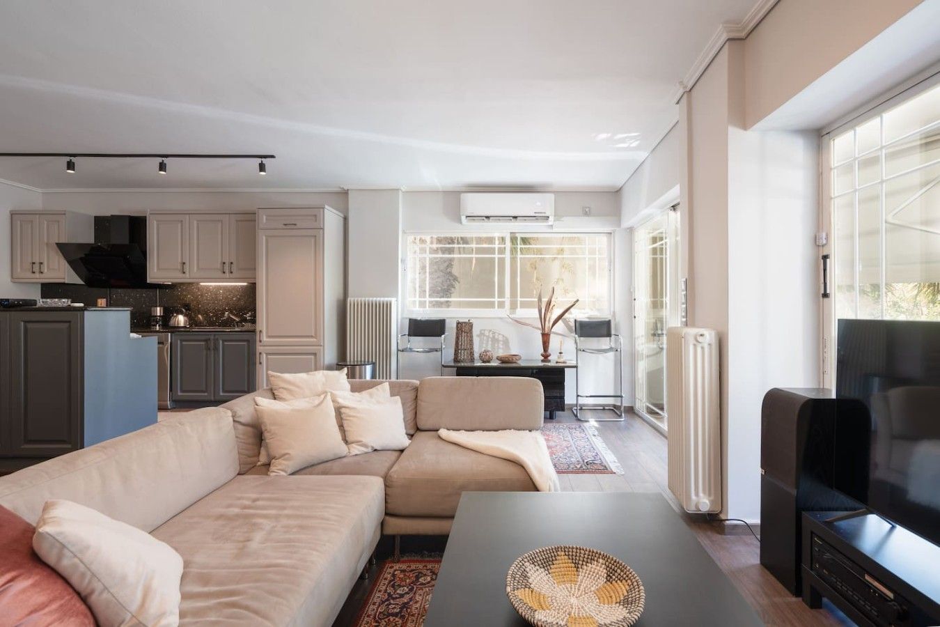 A modern living room with a sectional sofa, a coffee table, and a television.
