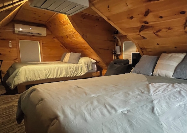 A cabin with two bedrooms, each with a bed and a nightstand.