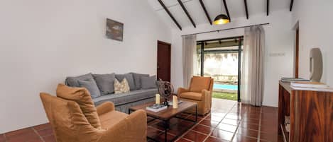A modern living room with a sofa, two armchairs, a coffee table, and a ceiling fan.