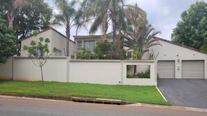 Un edificio residenziale con garage, un piccolo giardino e vialetto lastricato.