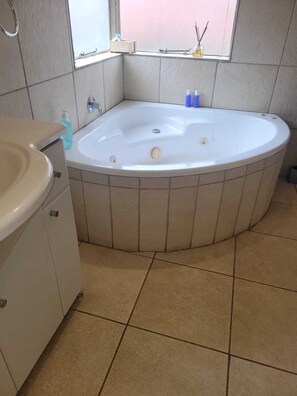 Ein Badezimmer mit Badewanne, Waschbecken und Fenster.