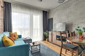 Ein modernes Wohnzimmer mit Sofa, Couchtisch und einem Essbereich mit Tisch und Stühlen.