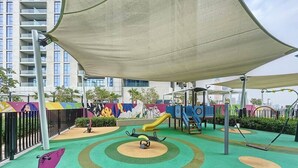 A children's play area with a slide, swings, and a climbing structure. - Luxe Studio in Prime Area l City View (Business Bsy)