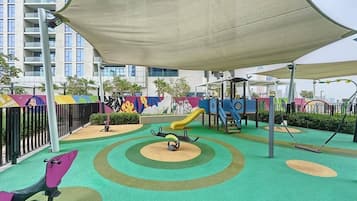 A children's play area with a slide, swings, and a climbing structure.