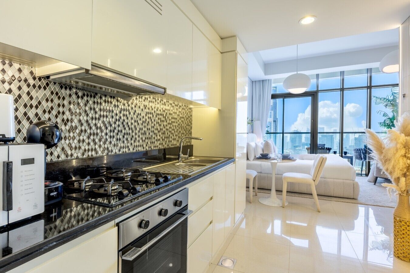 A modern kitchen with a gas stove, oven, and a patterned backsplash.