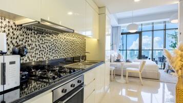 A modern kitchen with a gas stove, oven, and a patterned backsplash.