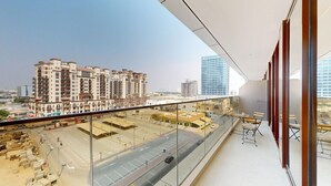 En balkong med utsikt över en stadsbild, inklusive höga byggnader och en byggarbetsplats.