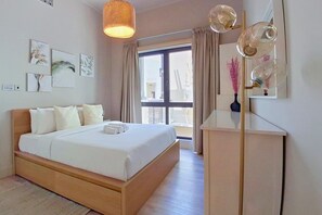 A hotel room with a bed, a bedside table, a mirror, and a window with curtains. - Central 1 Bed l Minutes Walk to Dubai Mall (Downtown)