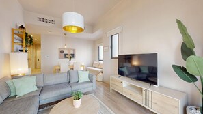 A modern living room with a sectional sofa, a flat-screen TV, and a wooden coffee table. - Central 1 Bed l Minutes Walk to Dubai Mall (Downtown)
