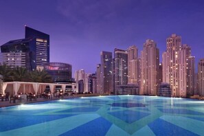 Eine Stadtsilhouette mit Wolkenkratzern und einem Pool mit geometrischen Mustern.