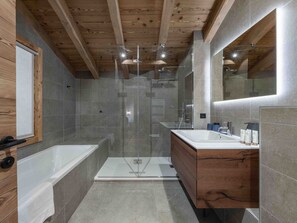 A modern bathroom with a glass shower enclosure, a wooden vanity with a mirror, and a bathtub. - Luxury chalet near slopes - 12 guests (Méribel)