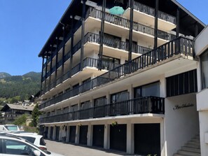 A multi-story hotel with balconies, a sign reading 'Les Chalets,' and a mountain backdrop. - Central apartment, pets allowed - 5 guests (Châtel)