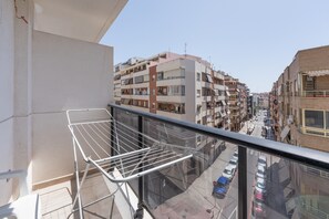 A balcony with a metal drying rack, overlooking a street with parked cars and multi-story buildings. - Apartment 'Edimar' with Balcony and Air Conditioning (Benidorm)
