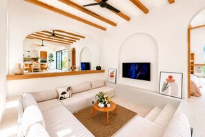 Una sala de estar moderna con un sofá, una mesa de centro y un televisor montado en la pared.