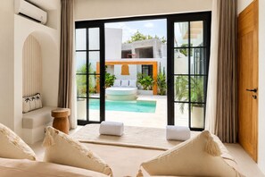 A modern bedroom with a large sliding glass door leading to a pool area. - Private 1BR Pool Villa with Bathtub, BBQ & Sunken Lounge in Bingin (Bingin)