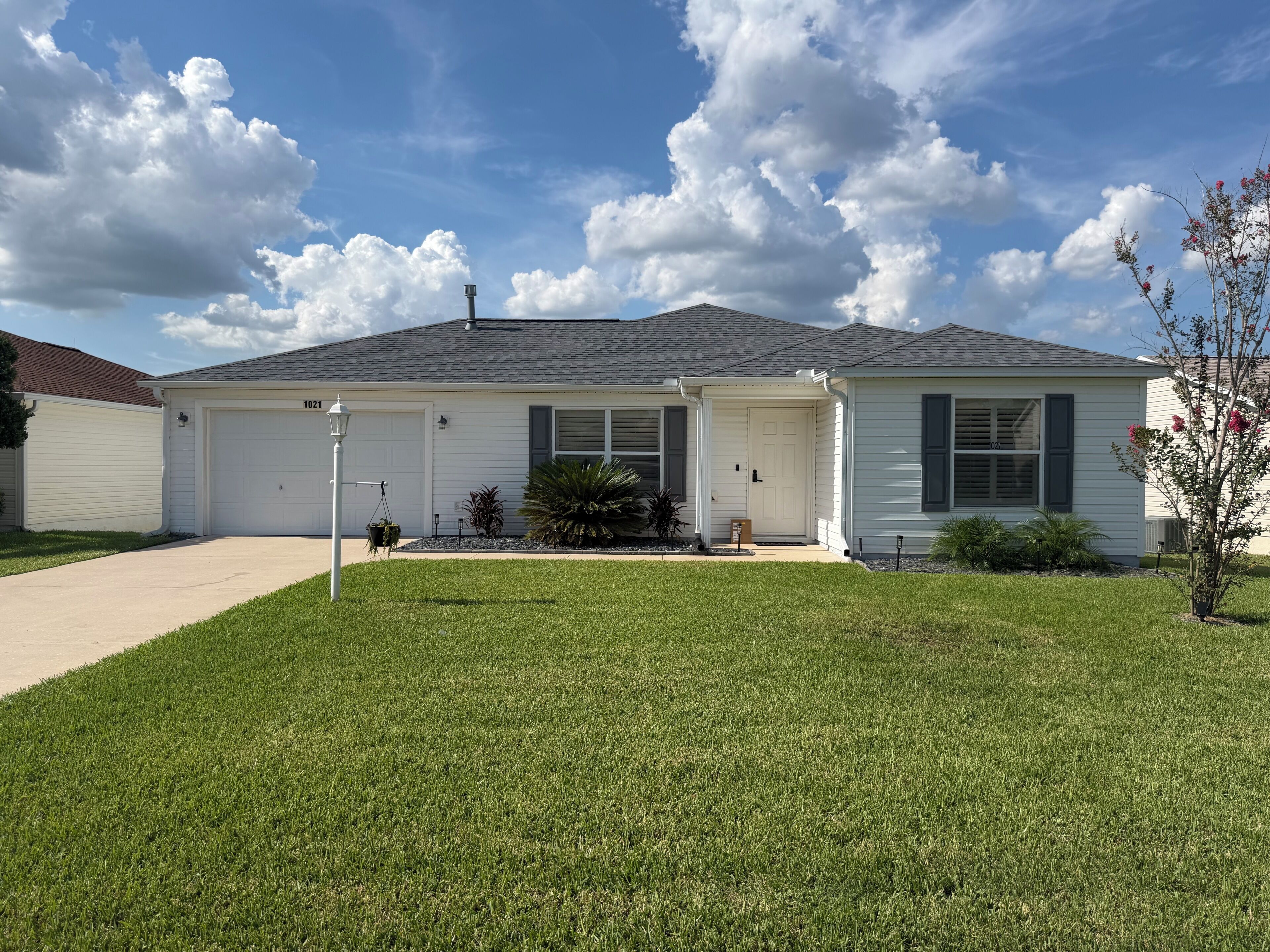 A single-story house with a garage, a front porch, and a well-maintained lawn.