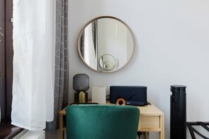 A room with a round mirror, a desk with a laptop, a microphone, a speaker, and a heater. - Musical 2BDR Retreat in the Heart of Camden (Greater London)