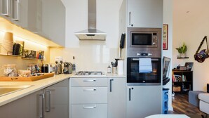 Eine moderne Küche mit Edelstahlgeräten, einem Gasherd und einem Backofen.