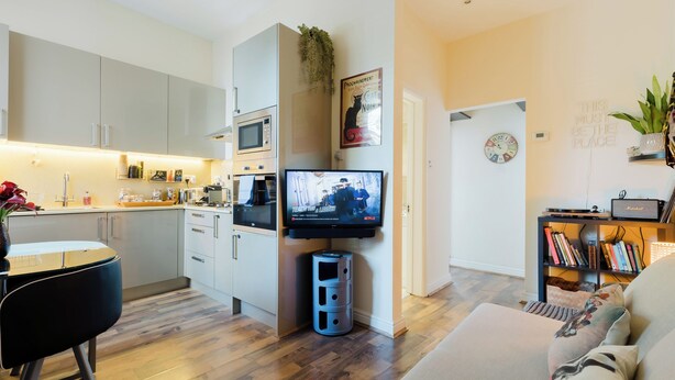 Eine moderne Wohnung mit Küche, Wohnbereich und Fernseher.