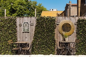 A wooden fence with a decorative window and a circular mirror. - Musical 2BDR Retreat in the Heart of Camden (Greater London)