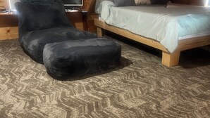 A cozy room with a bed, a chair, and a television. - Water Front 1 bedroom house on tranquil Smith Island (Smith Island)