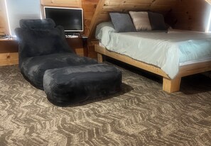 A cozy room with a bed, a chair, and a television. - Water Front 1 bedroom house on tranquil Smith Island (Smith Island)