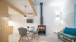 Una sala de estar moderna con chimenea, un comedor con sillas y un sofá.